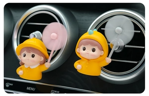 Close-up of cute cartoon characters in yellow raincoats on car air vent fragrance clips