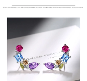 Close-up of elegant silver stud earrings with multi-colored gemstones in curved arrangement