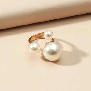 Adjustable gold ring featuring three round pearls on a minimalist polished metal band