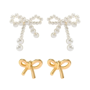 Close-up of pearl beaded bow earrings and polished gold metal bow studs for women
