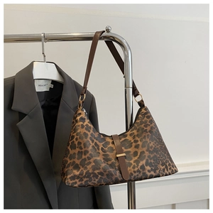 Detail der Schultertasche mit Leopardenmuster, braunem Gurt und Schnallenverschluss
