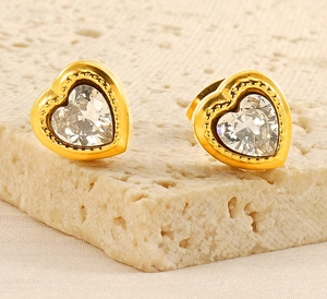 Macro shot of gold-plated heart studs with large zircon center and beaded edge details