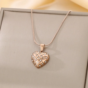 Detailed view of rose gold heart pendant with woven texture and sparkling rhinestones