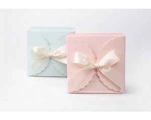 Close-up of pink and light blue square gift boxes with beige bow ribbon details