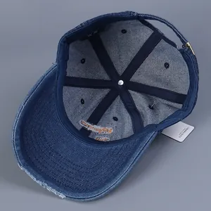 Internal view of distressed denim baseball cap showing six-panel structure and metal buckle