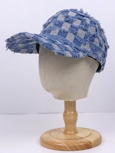 Detailed view of checkered denim baseball cap with distressed fringe and vintage edges