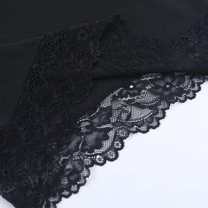 Gros plan sur la dentelle noire délicate et les coutures de ce t-shirt court élégant