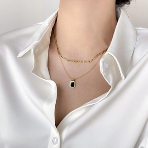 Double-layer golden necklace with black geometric square pendant in a vintage design