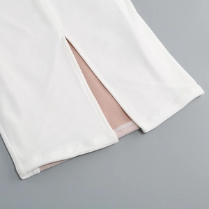 Detail view of white velvet dress hem featuring a side slit and nude inner lining