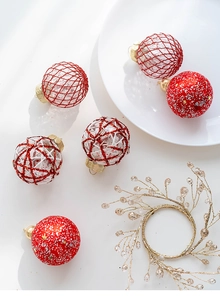 Detailed close-up of red and gold glitter Christmas baubles with snowflake patterns