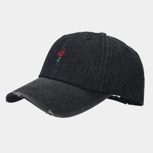 Detail view of red rose embroidery on a black washed denim baseball cap with curved brim
