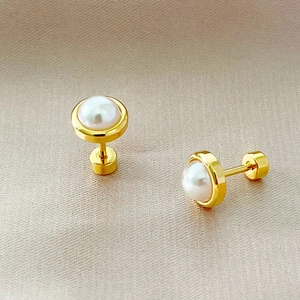 Minimalist gold pearl stud earrings with secure screw back on champagne silk fabric