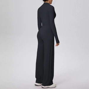 Détail de l'ensemble de sport noir avec haut zippé et pantalon de yoga large