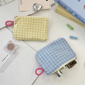 Close-up of checkered small storage pouch with a pink loop on a clean desk
