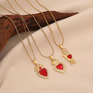 Golden stainless steel necklaces with red heart zircon pendants on a wooden display