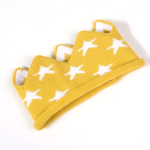 Gros plan du bandeau couronne en tricot jaune avec motifs d'étoiles blanches pour bébé