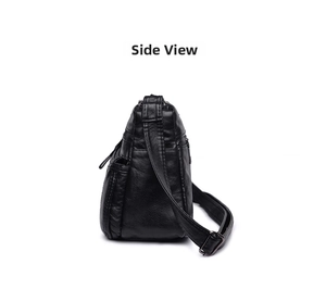 Detail view showing side pocket zipper and texture of black washed leather shoulder bag