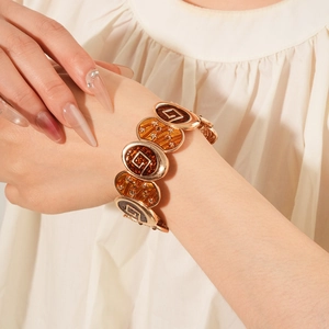 Détail d'un bracelet vintage doré avec maillons émaillés et motifs d'étoiles fins