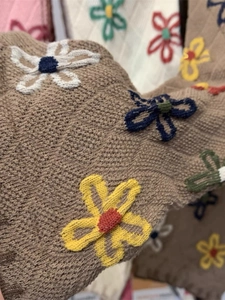 Close-up of brown knit socks with colorful embroidered flower patterns and texture