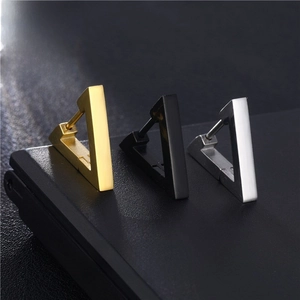 Macro view of triangular stainless steel hoop earrings in gold, black, and silver finishes