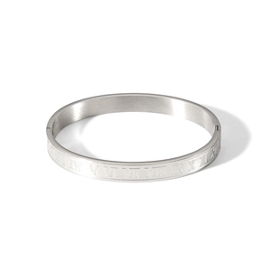 Macro shot of silver stainless steel bangle featuring roman numeral engraved markings