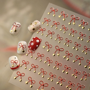 Red bow and gold star nail art stickers with glossy festive manicure effect