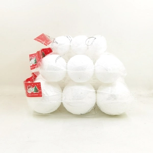 Close-up of white foam Christmas balls with silver hangers inside plastic packaging