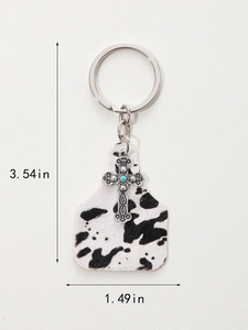 Detailed view of vintage cow print cross keychain showing size dimensions 3.54in by 1.49in