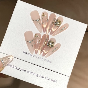 Detail of almond-shaped press-on nails with champagne rhinestones and cat-eye finish