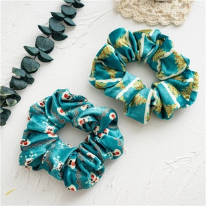 Detail of soft plush Christmas scrunchies featuring festive reindeer and tree prints