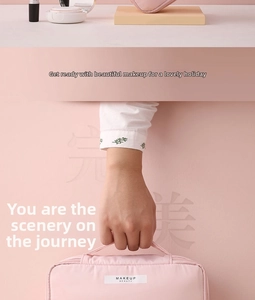 Close-up of pink waterproof makeup bag with hand holding top handle and fabric tag