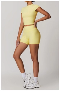 Detail view of the seamless fabric texture on light yellow yoga crop top and shorts set