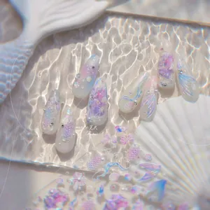 Détail de nail art sirène 3D avec perles, coquillages et paillettes effet aurora