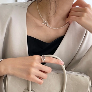 Polished silver chain necklace and zircon ring styled with a minimalist beige blazer