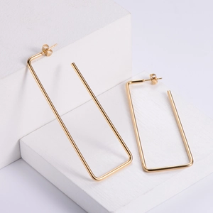 Minimalist gold-plated stainless steel rectangular hoop earrings on stone display