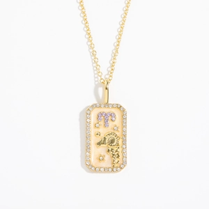Detail of a vintage golden Aries zodiac necklace with zircon border and purple enamel