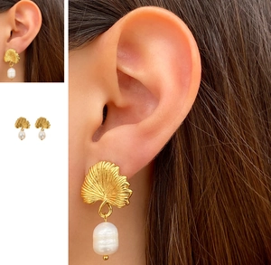 Détail de boucles d'oreilles feuilles de ginkgo en or 18k avec perles sur un modèle