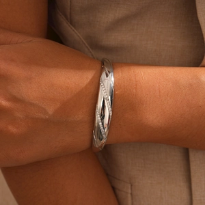 Close-up of silver-plated bracelet with diagonal pavé zircon inlay on model wrist