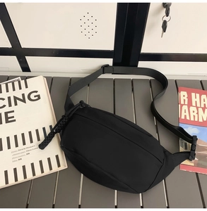 Close-up of black crescent canvas bag with adjustable strap and textured zipper pulls