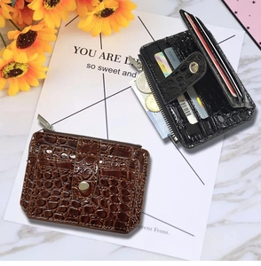 Detail of crocodile pattern card wallets in brown and black with zipper pocket