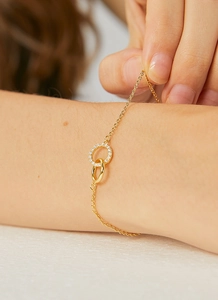 Detail of gold-plated double ring bracelet with sparkling pavé cubic zirconia