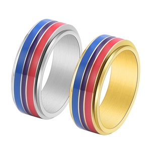 Close-up of spinning stainless steel rings with colorful enamel stripes and brushed finish
