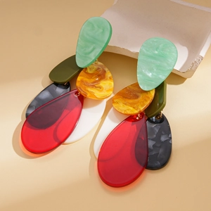 Detailed close-up of acrylic teardrop earrings with colorful marble texture on stone