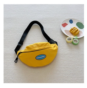 Detail of a bright yellow canvas chest bag with adjustable strap and logo for kids