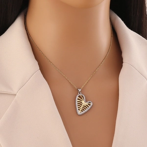 Détail du collier cœur bicolore avec design de cage thoracique et pierres zircons