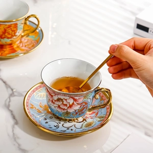 European luxury ceramic floral tea cup and saucer set with gold trim on marble surface