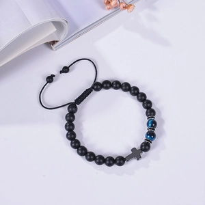 Detail of 8mm black matte stone beaded bracelet with blue cat eye bead and metal cross