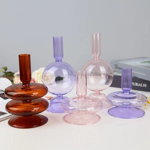 Set of modern colorful geometric glass candle holders in amber, purple, and pink tones
