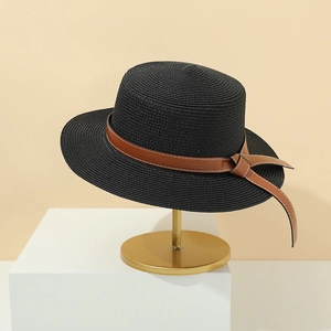 Close-up of black straw boater hat featuring a brown leather strap and side bow