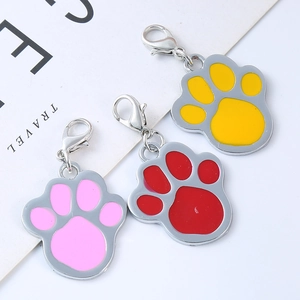 Detailed view of paw-shaped pet tags with yellow, pink and red enamel finish